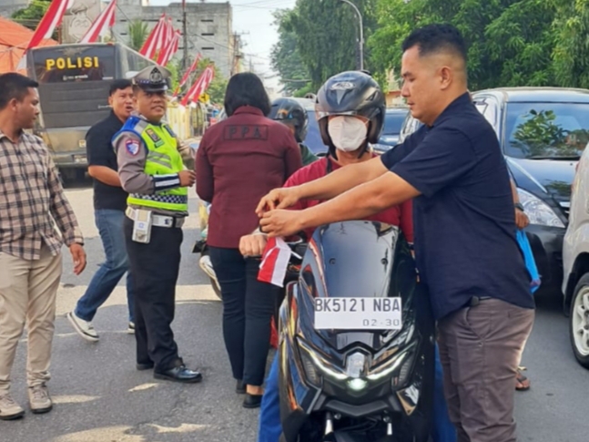 Kasat Reskrim Polres Tebing Tinggi Bagikan Bendera kepada Masyarakat Pengguna Jalan