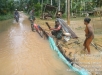 Akibat Luapan Banjir Babinsa Koramil 01/Rengat Bantu Warga Desa Binaan Buat Bendungan.